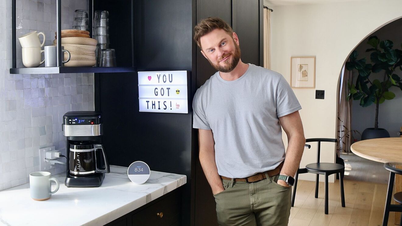 Bobby Berk in kitchen with Echo Spot, coffee maker, and light box message that says 'You Got This!'