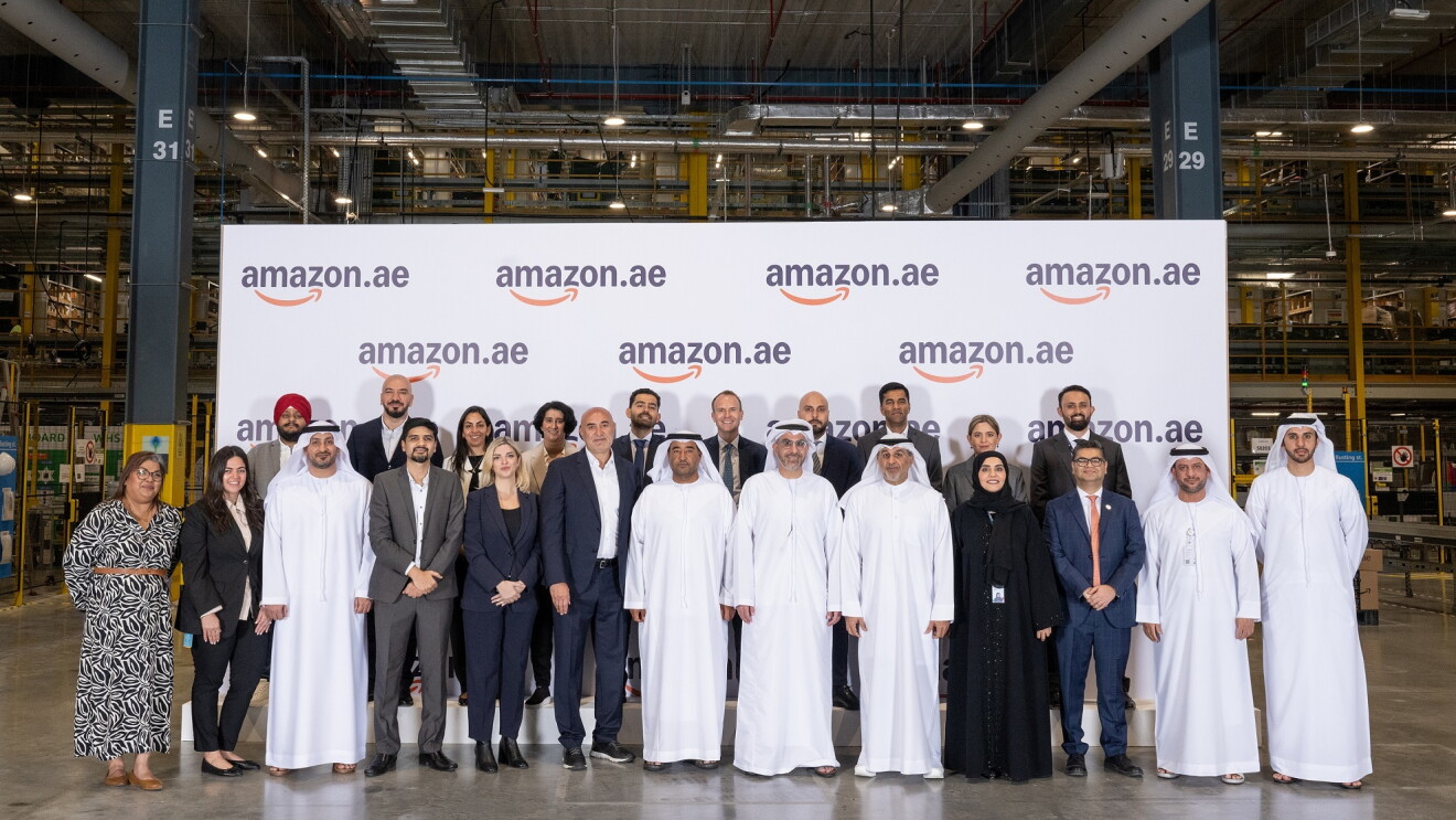 Image of people standing in front of an Amazon.ae branded rollup