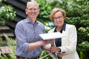 An image of Dave Limp and Margherita Della Valle holding a Project Kuiper customer terminal with plants in the background. 