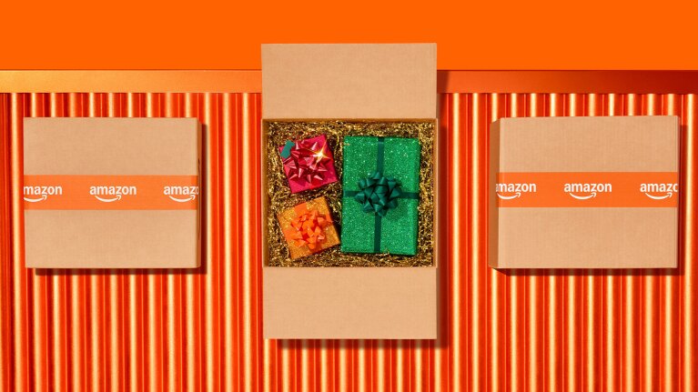 Amazon boxes surrounding gift-filled package on orange background