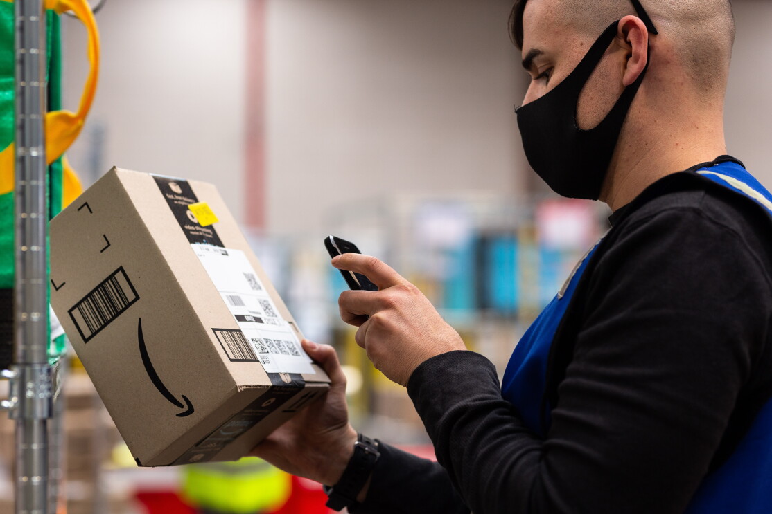 An Amazon Flex delivery partner scans a package at the delivery station.