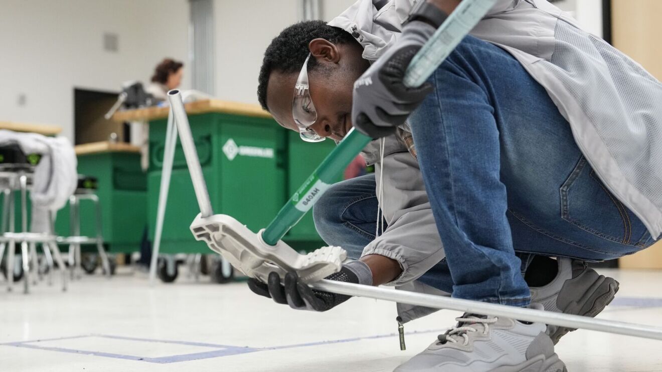 Young students assembling robotics project on floor of tech lab