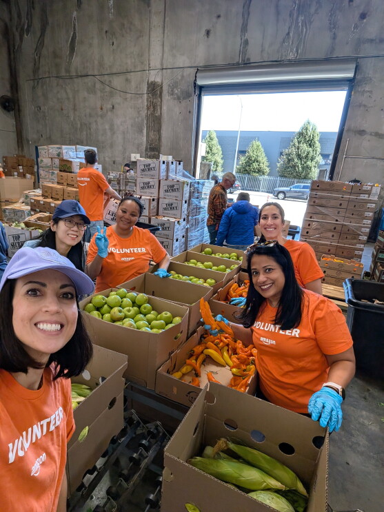 Amazon employees pack fresh produce for a local food bank.
