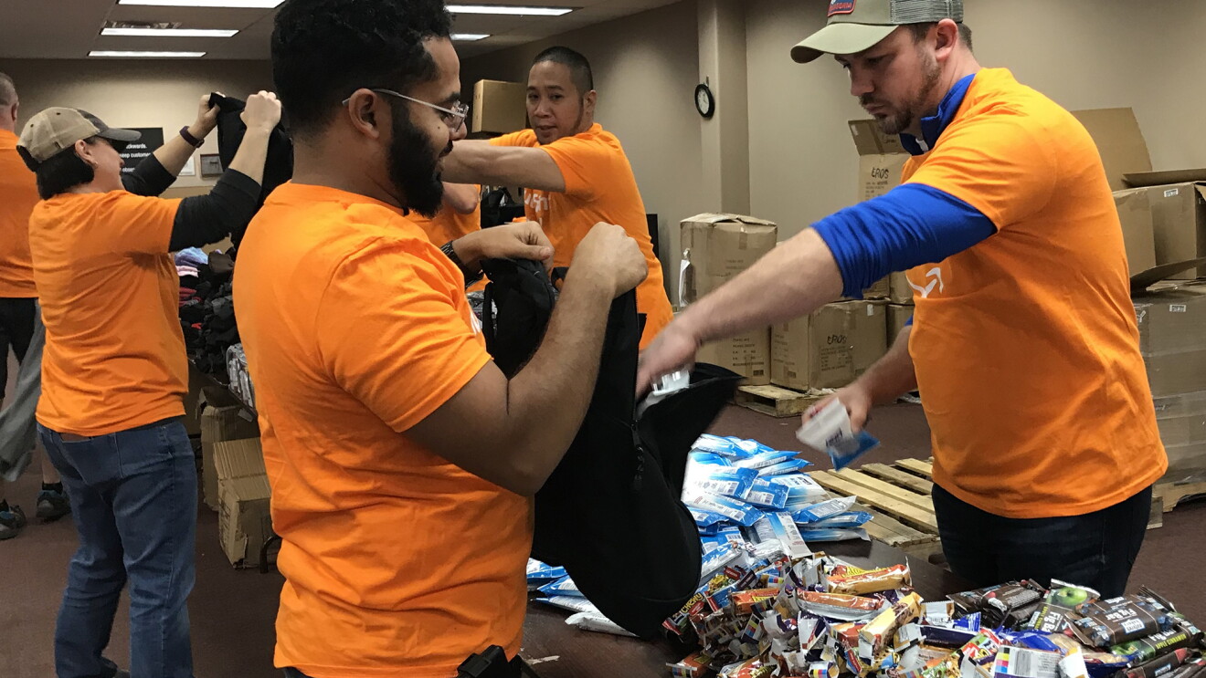 Amazon associates filling backpacks with essential items 