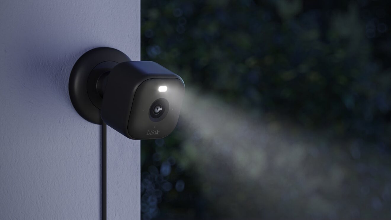 Blink security camera with illuminated LED on dark exterior wall