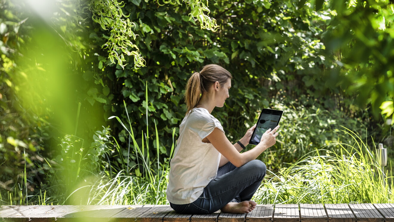 Eine junge Frau liest mit ihrem E-Reader