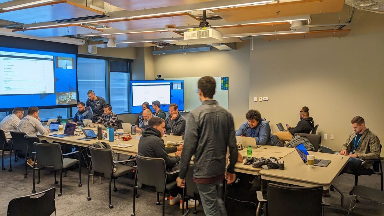 An image of the AWS Intelligence Initiative team working together in a conference room.