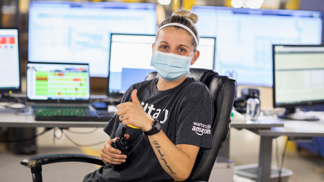 An image of an Amazon employee working at Amazon while wearing a shirt that says "military" with the Amazon logo under it.