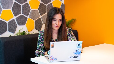 Mujer con ordenador en una mesa de trabajo.