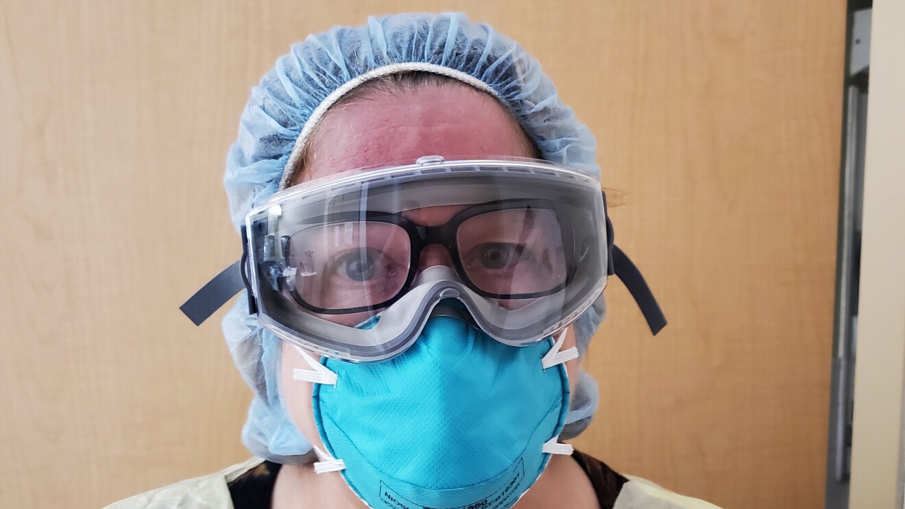 A woman wearing PPE has her Echo Frames on under her goggles, as a Physician's Assistant.