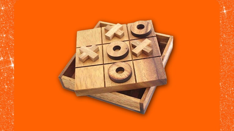 Wooden tic-tac-toe game set on vibrant orange background