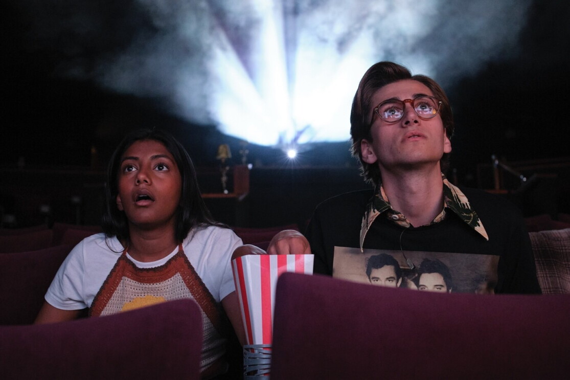 A teenage boy and girl in the cinema eating popcorn 