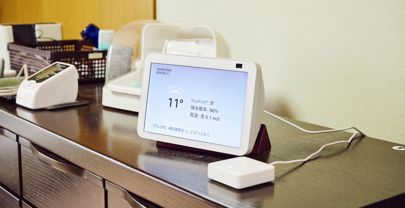 腰高くらいのタンスの上に置かれた白いEcho Show8。その横に白い直方体の器具（スマートリモコン）がある