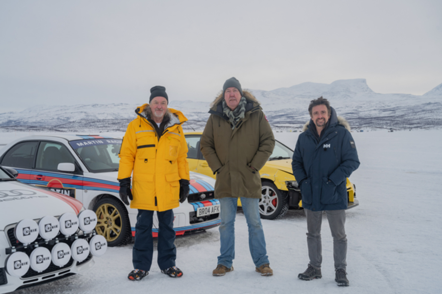 Three men (Jeremy Clarkson, James May and Richard Hammond) stand next to three cars in an icy location