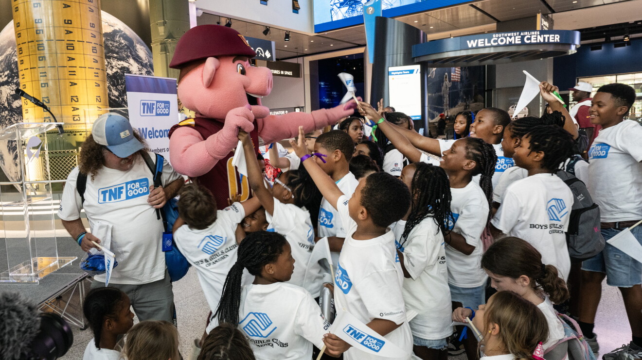 Mascot interacts with excited children at Welcome Center event