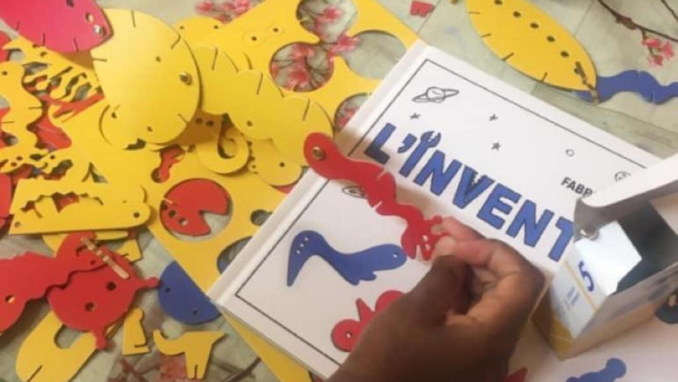 Primo piano di mani di bambini che giocano con ritagli di carta e album da disegno