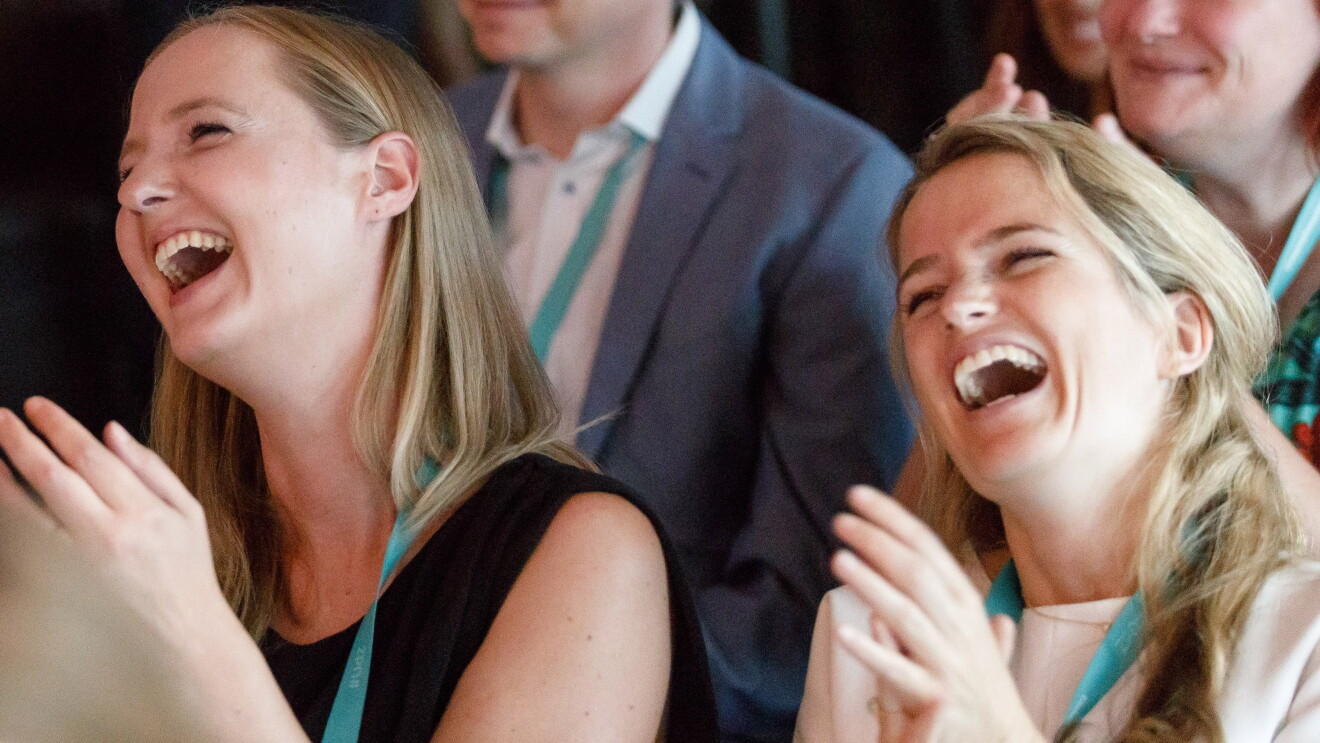 Zwei junge Damen sitzen im Publikum, klatschen und lachen laut