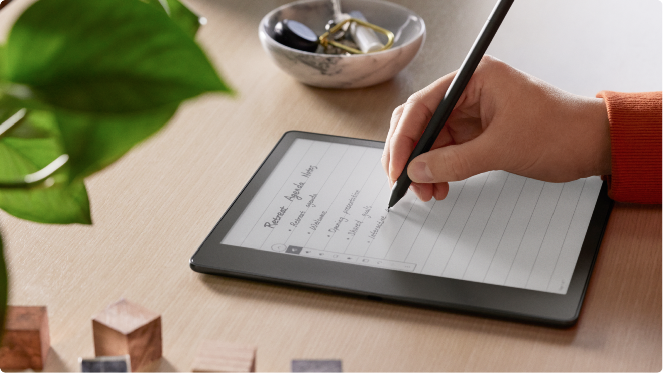 Someone writing notes on a Kindle Scribe using the premium pen