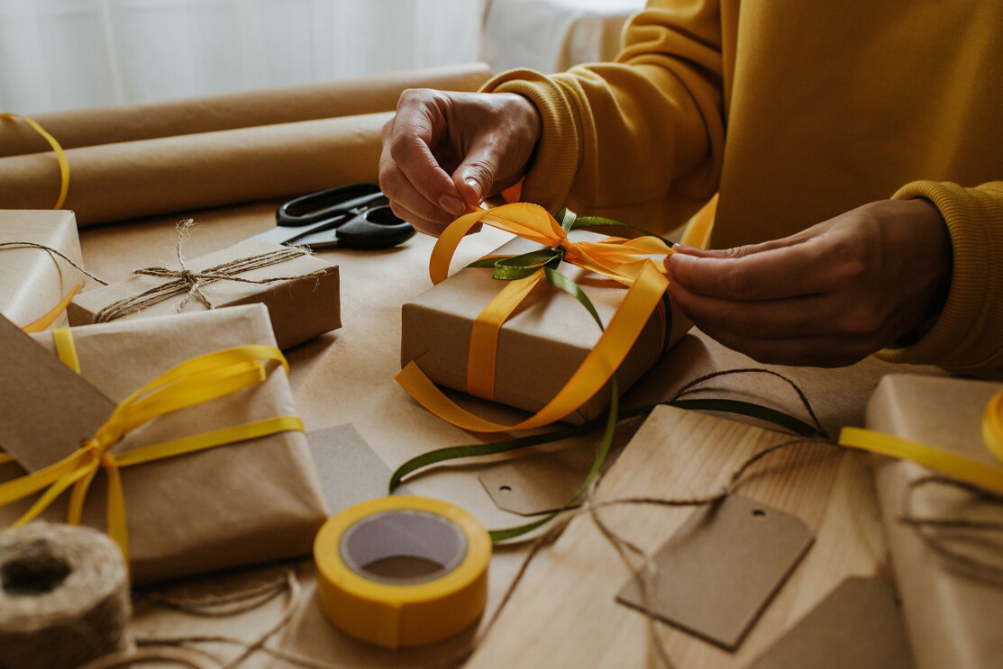 An image of a woman's hands wrapping gifts.
