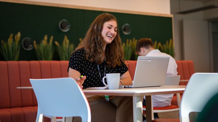 Smiling employee working on laptop in a modern office space