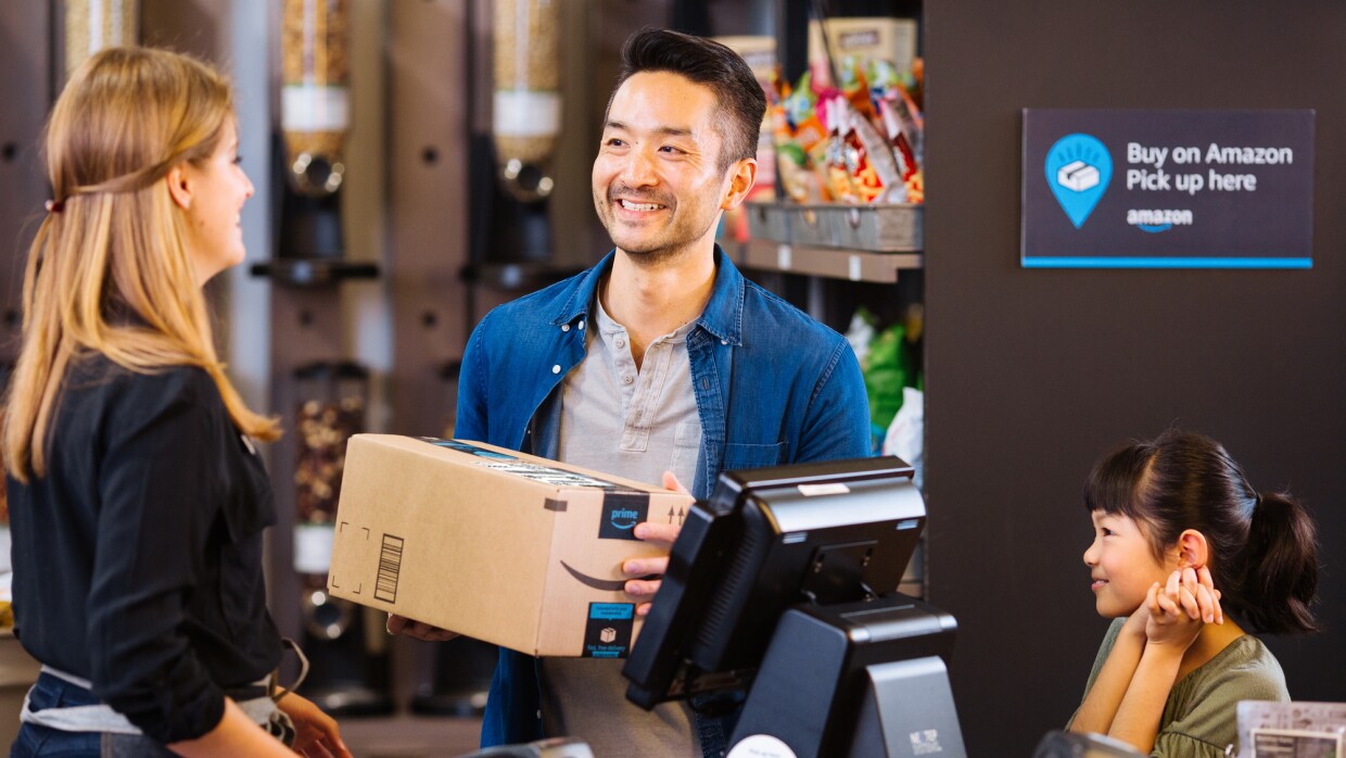 A smiling man receiving order from Amazon pickup location