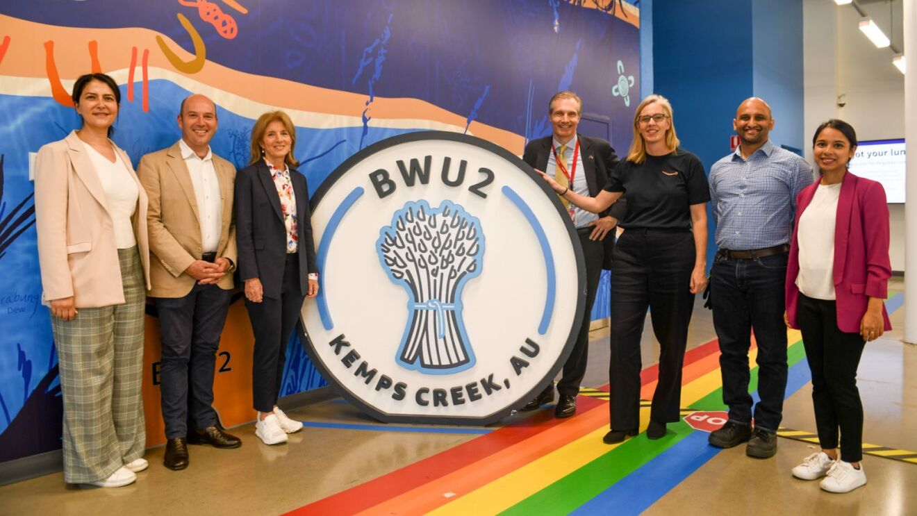 Ambassador Kennedy and Amazon teams in front of a mural in BWU2 created by three Western Sydney artists.