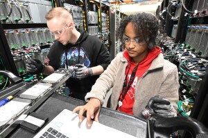 A photo of two data center technicians inspecting hardware inside an AWS Data Center. 