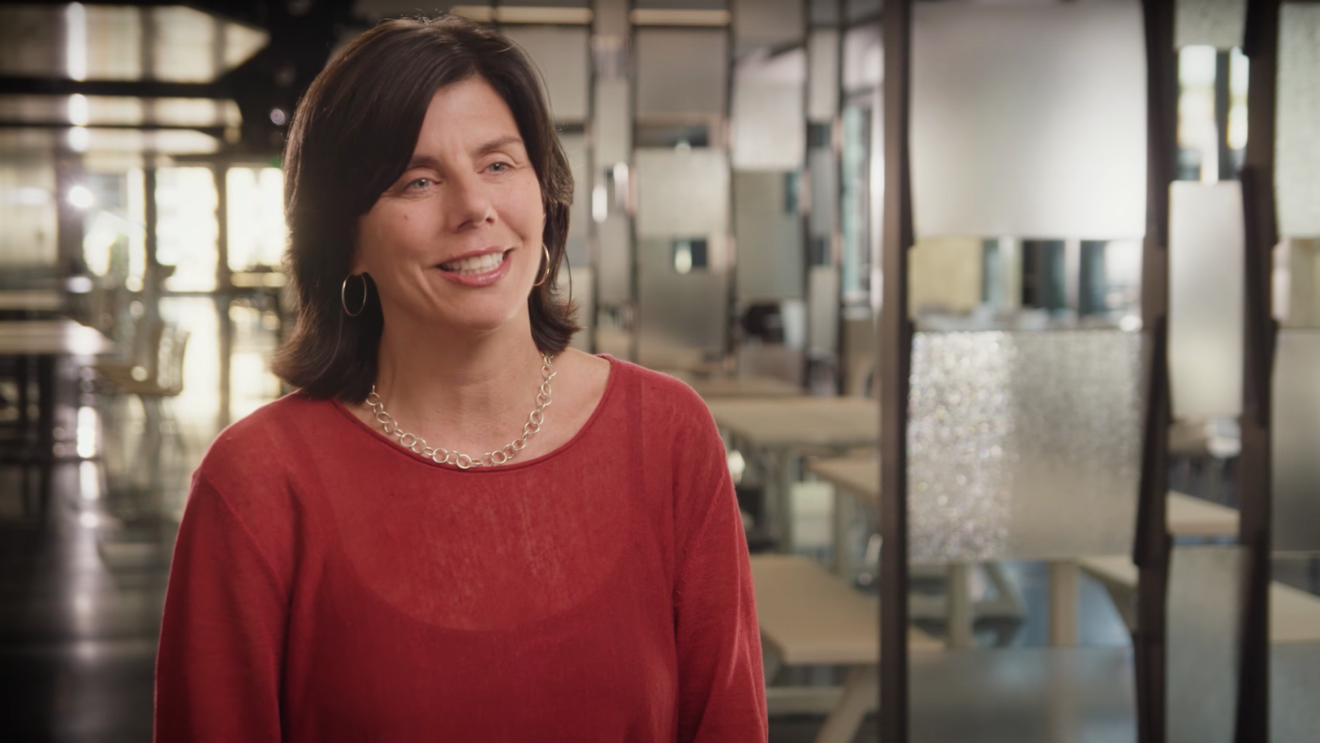 亚马逊的一位领导者,Jennifer Cast。背景是一个有座位和自然光的亚马逊工作空间。