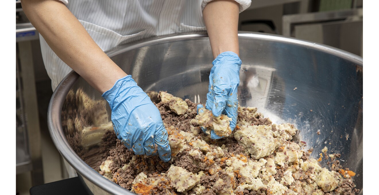 ゴム手袋をつけて、大きいボウルにはいった材料をほぐしていく様子