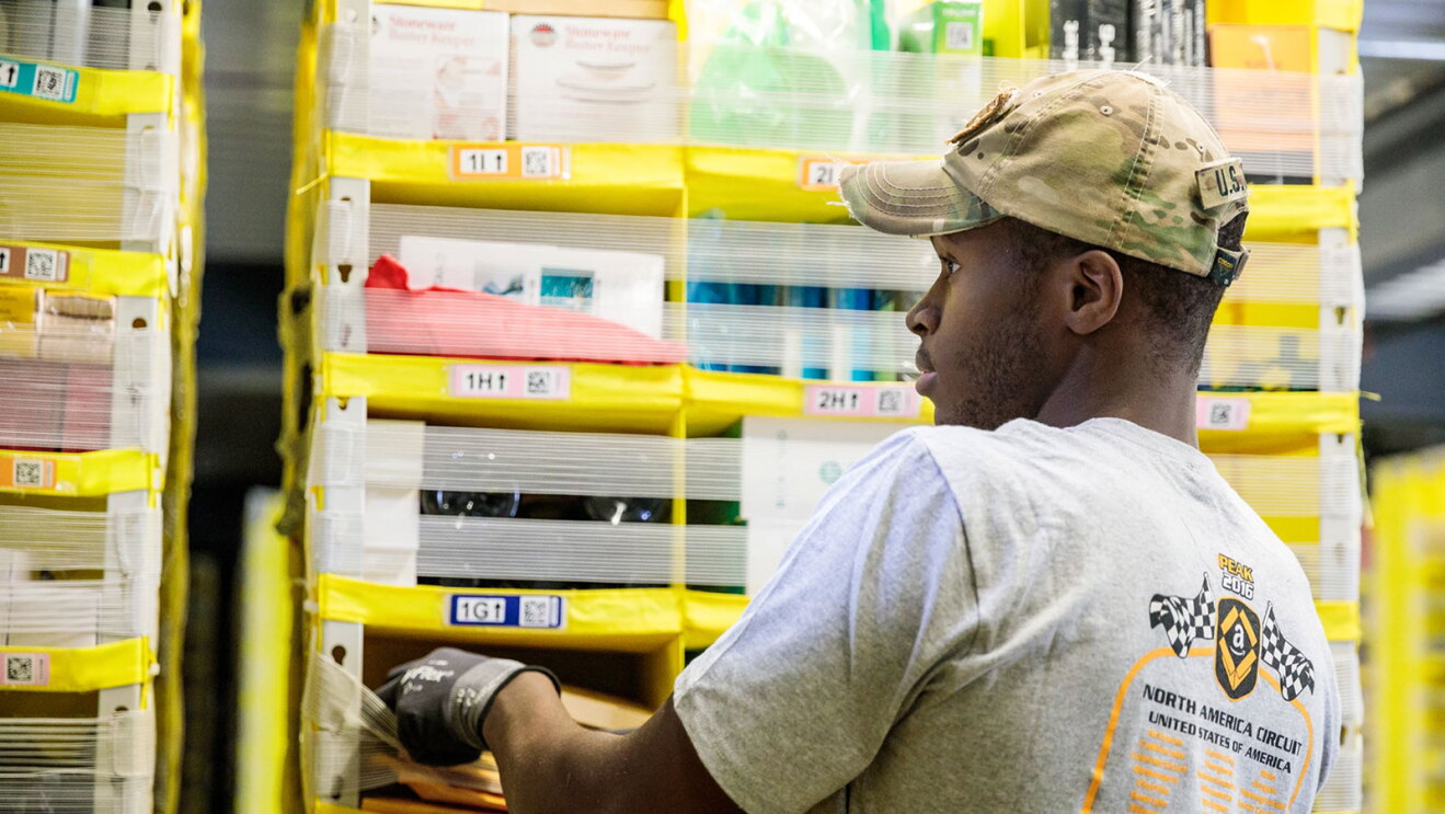 Amazon employee organizing inventory on shelves