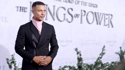 A man smiles for a photo on the red carpet of the Lord of the Rings the Rings of Power premiere