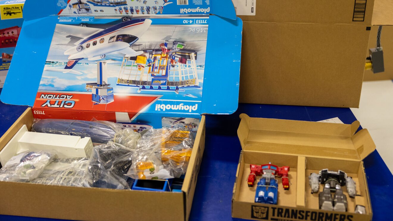 An image of a brown box with a colorful display inside that shows a toy set and information about the toy.