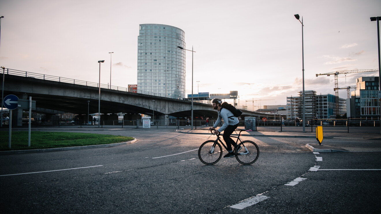 Person wearing a helmet and riding across the road on a bike 
