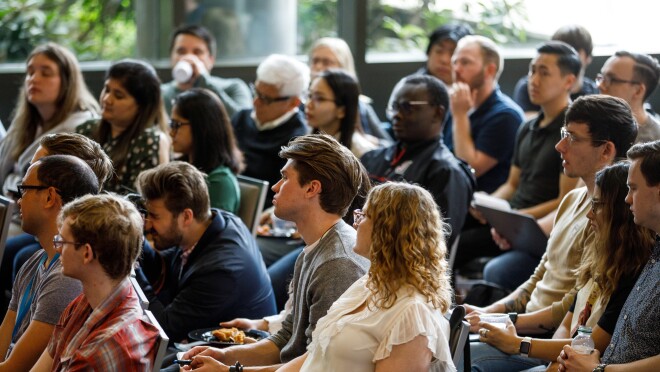 许多人坐着,因为他们在西雅图大学听炉边谈话。