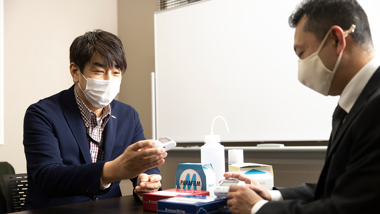 商品を手にして話す山下さんと内山さんの写真