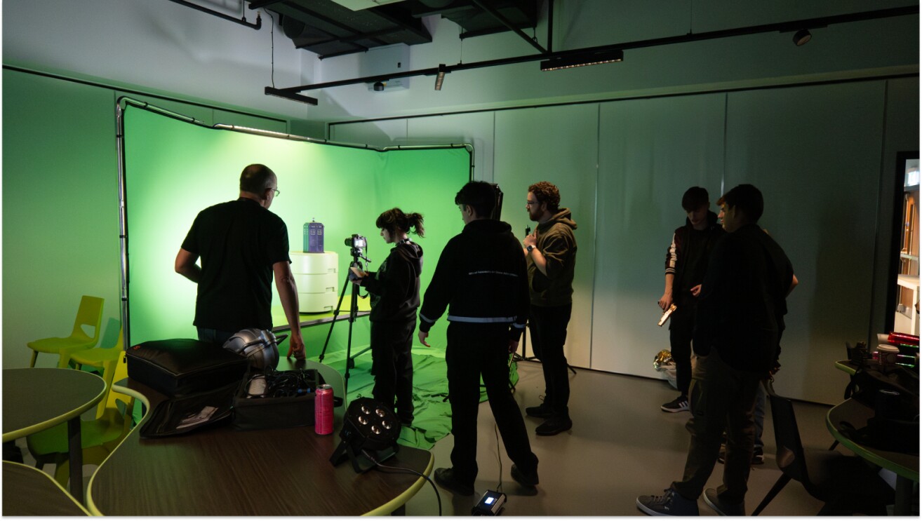 Film crew setting up green screen for video production