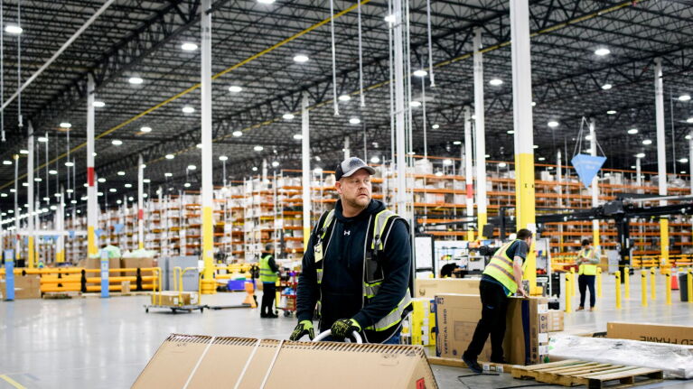 Industrial warehouse scene with employees processing packages