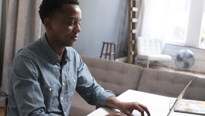 Amazon training program attendee sits at his desk and types on a laptop.