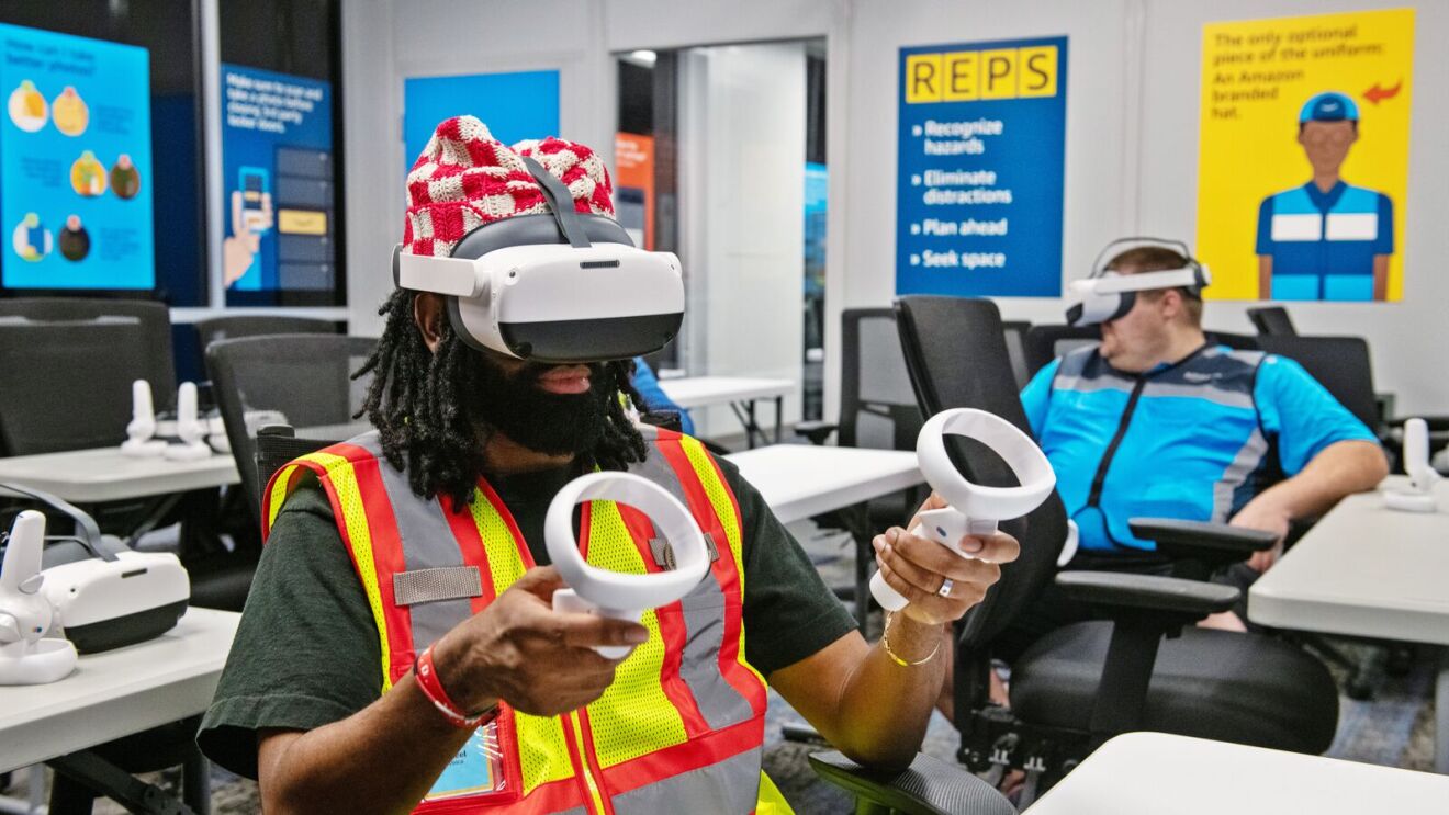 Two delivery drivers go through safety training with virtual reality headsets at an Amazon Last Mile Driver Academy.