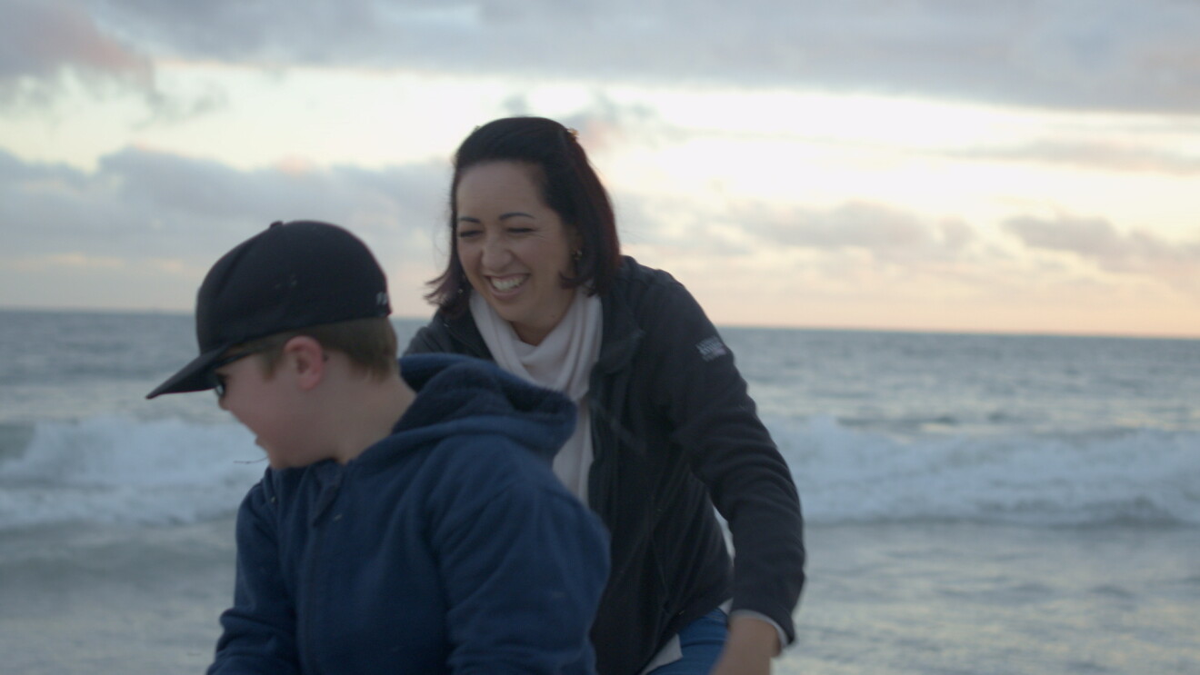 A woman plays with her son on the beach 