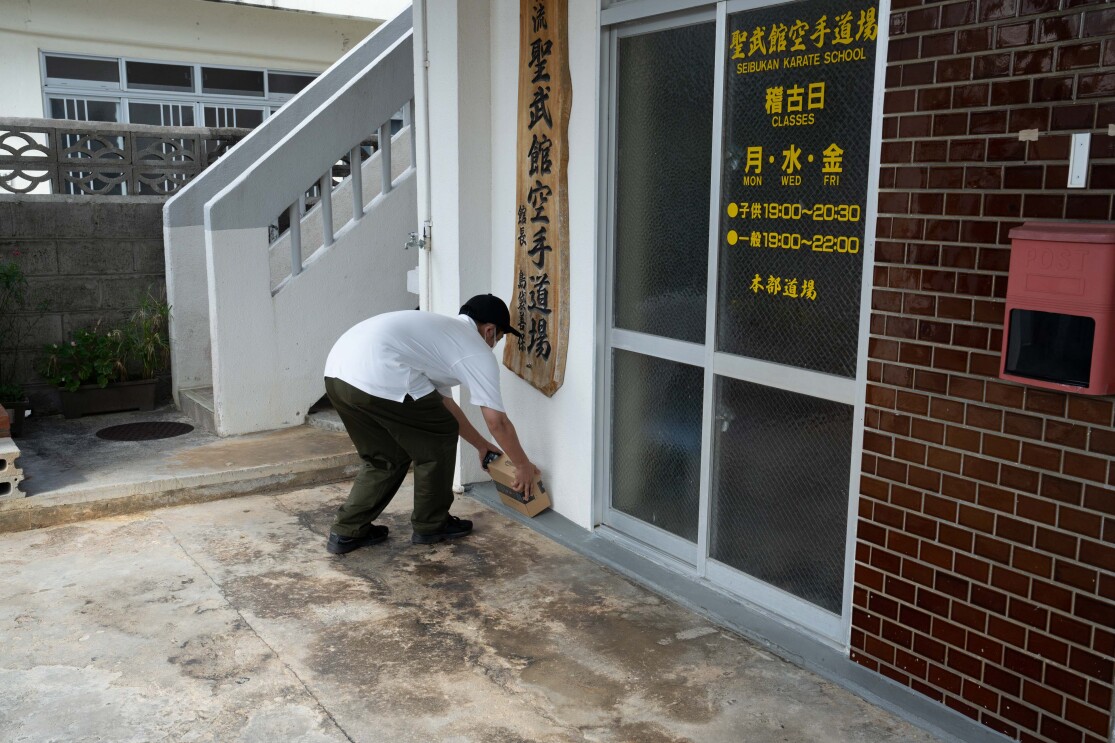 ドライバーが道場の前に商品を置いて配達を完了する様子