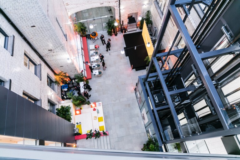 The modern office atrium viewed from above with colorful seating areas in Amazon's Manchester office
