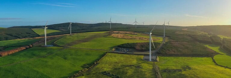 An image of a wind farm which is producing renewable energy.