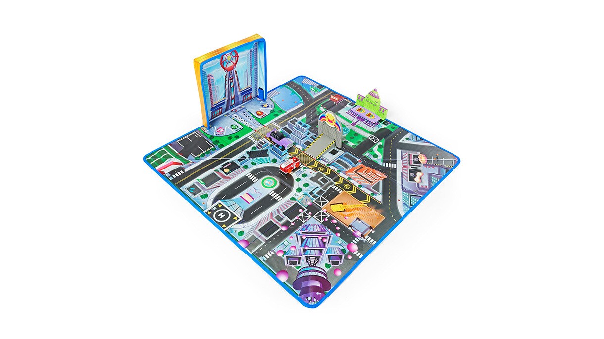 An image of a play mat with roads and city structures on it. There is a blue outline on the mat and some structures and trees are sticking out of it.