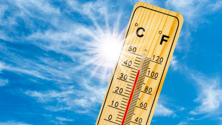 Sunny skies with a thermometer showing high heatwave temperatures