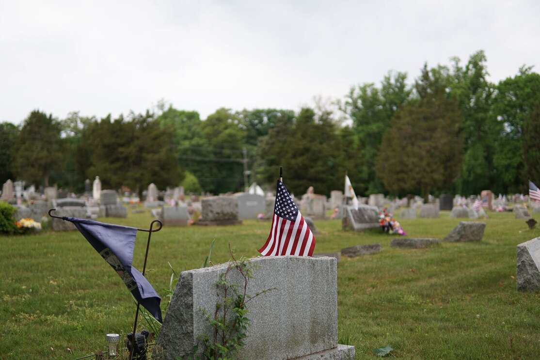 An image of Warriors@ members placing wreathes and flags on veterans' graves.