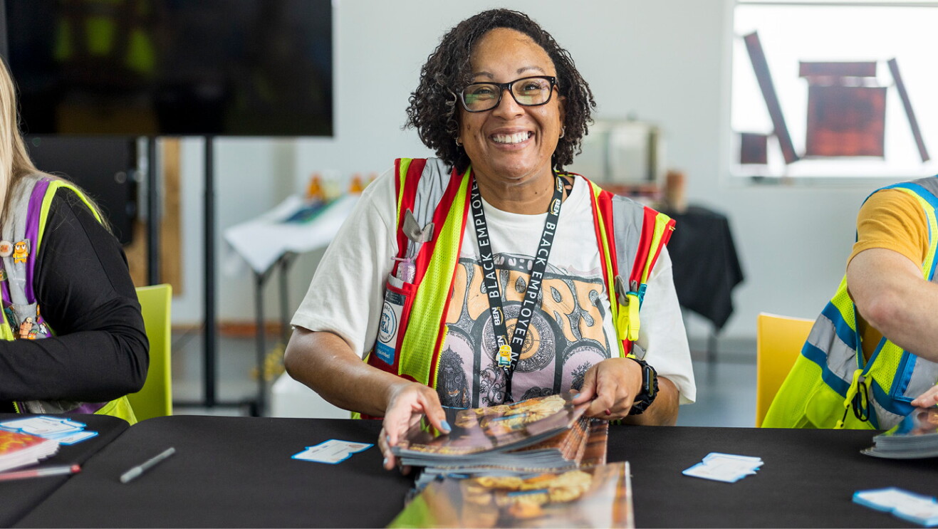 An image of an Amazon employee volunteer holding a stack of books to give away.