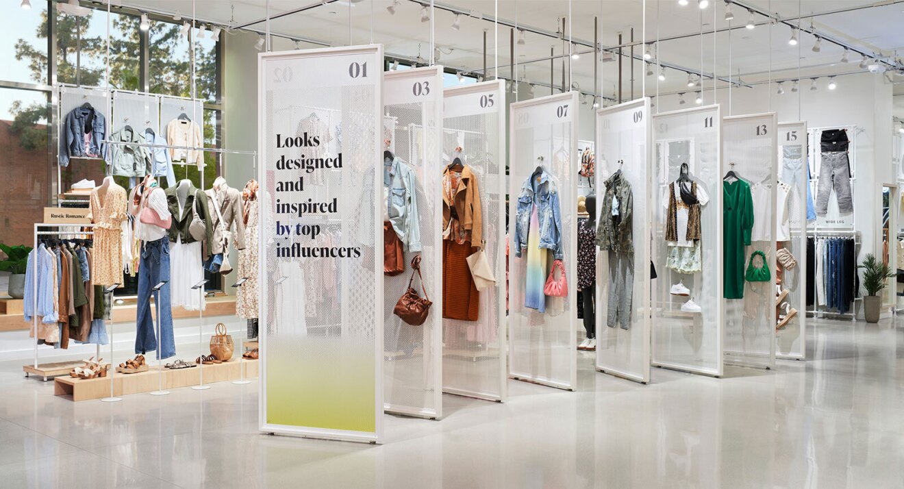 An image of an Amazon Style store. There are clothing racks and accessories throughout the store. There is a display that says "Looks designed and inspired by top influencers."
