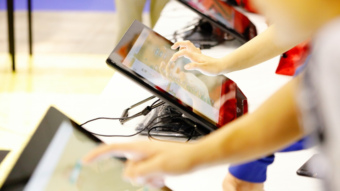Primo piano di mani di bambini che interagiscono con dei tablet. 