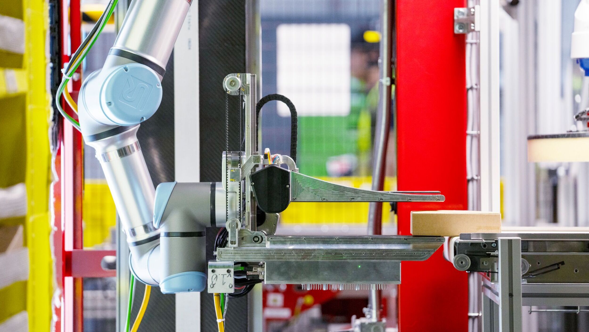 Amazon's new robot system, Vulcan, picking up a cardboard box.